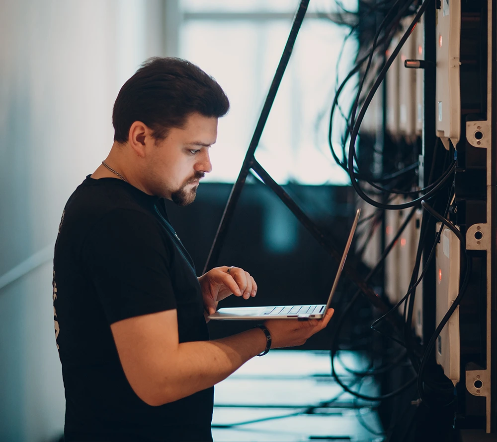 IT guy is working with laptop to solve network